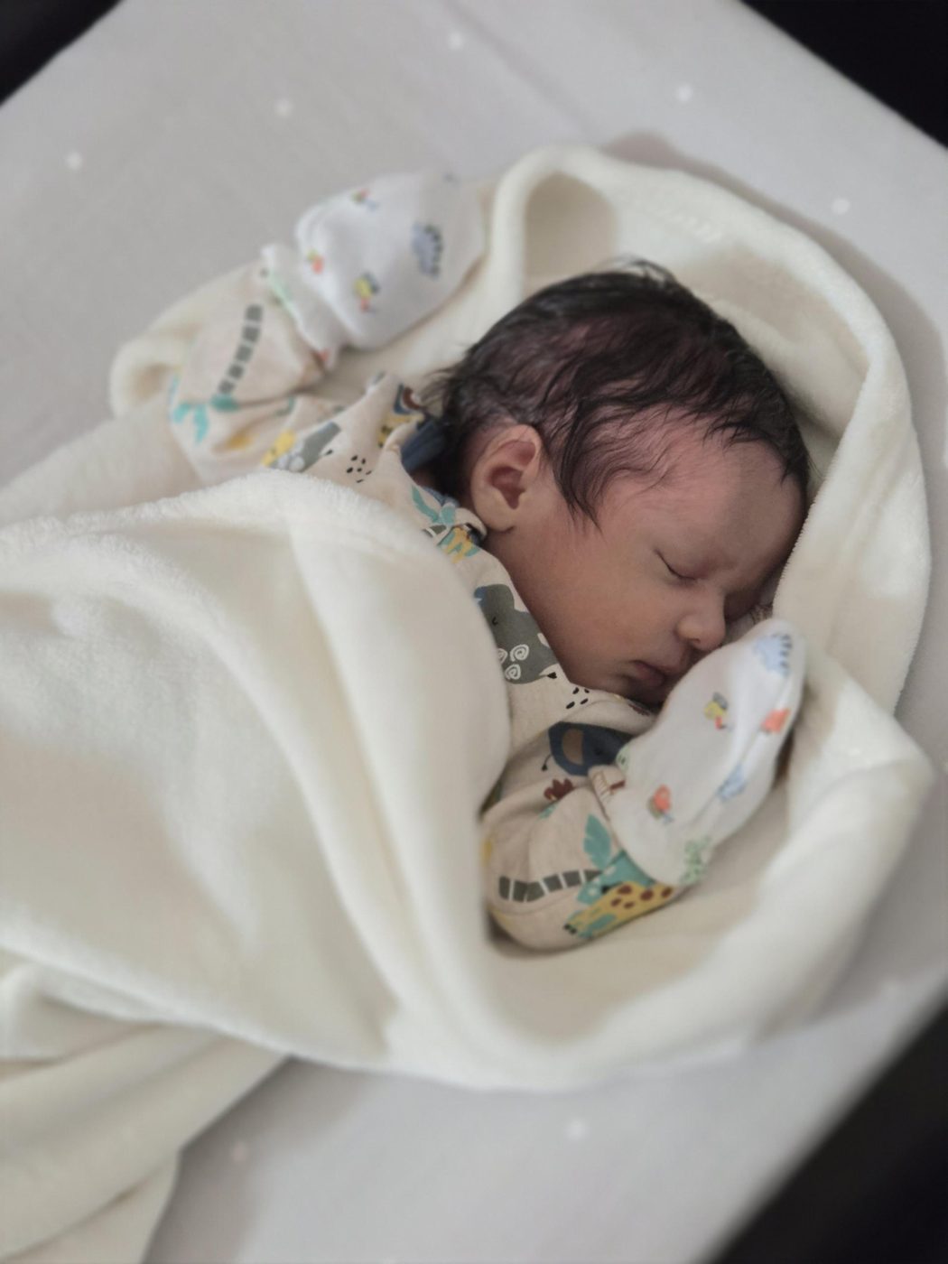 Faris bundled in a soft white blanket, fast asleep